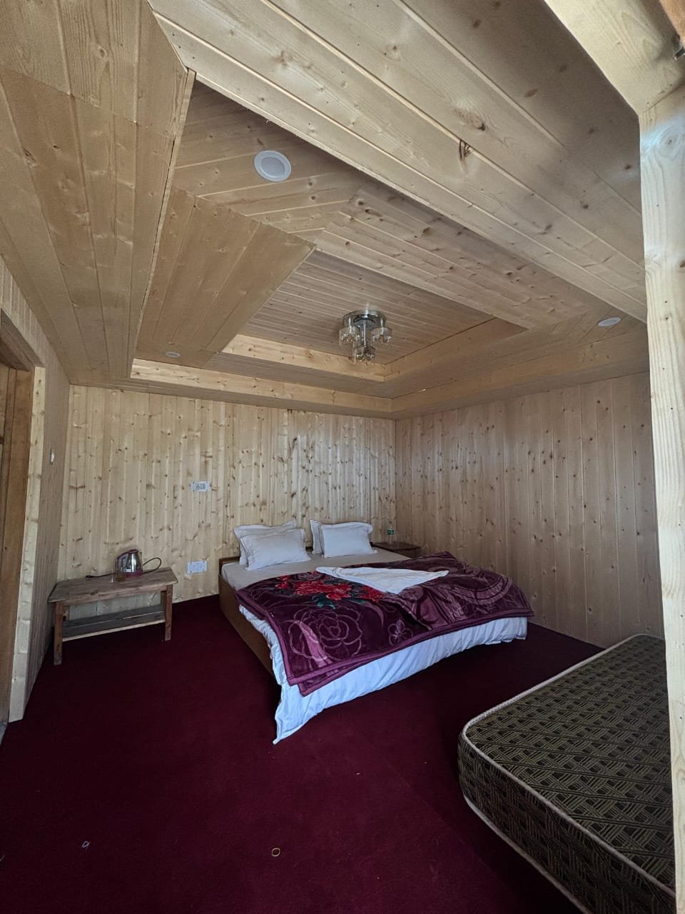 Heritage room interior with warm pine walls and deep red carpet