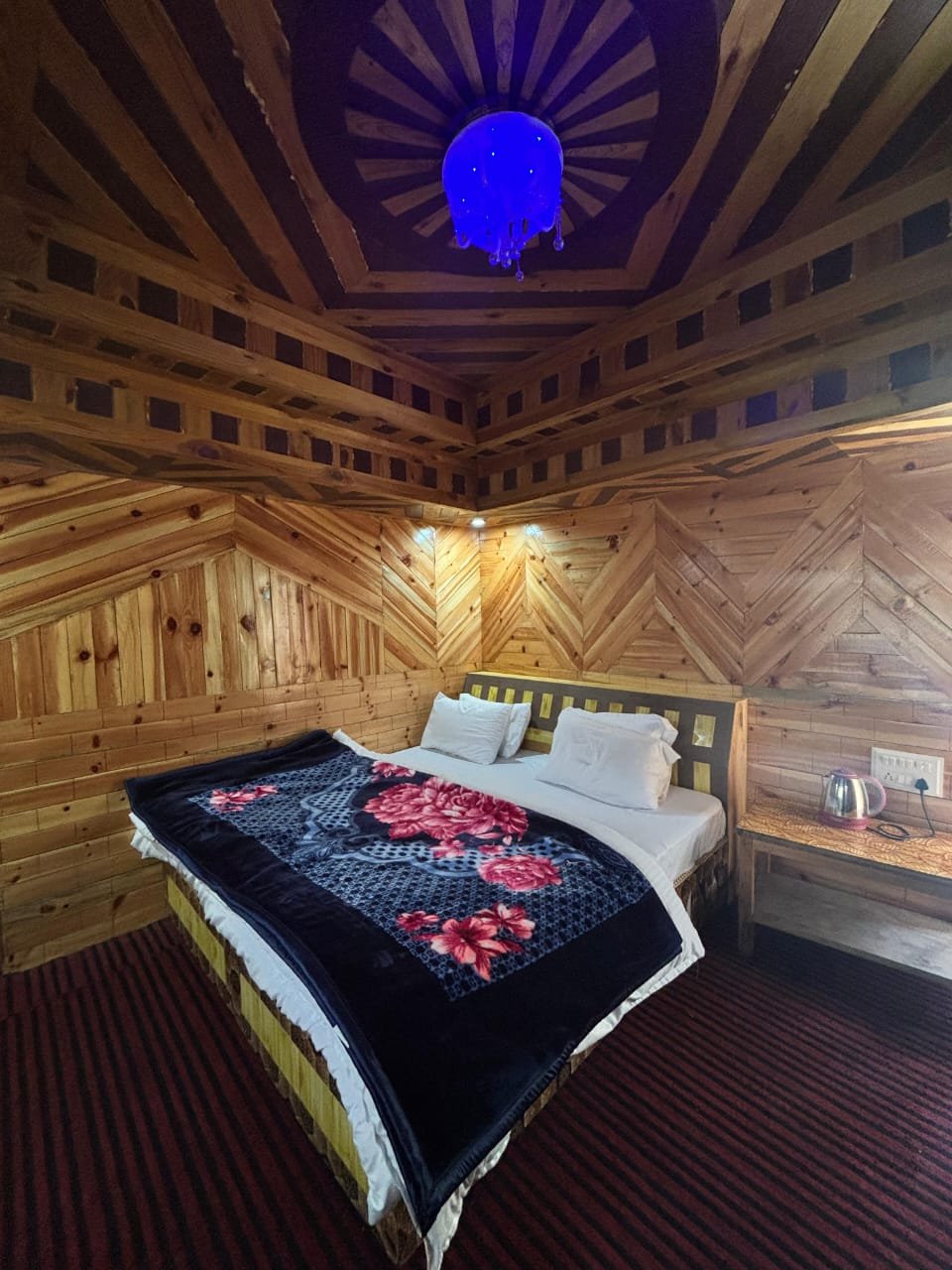 Heritage room: ornate octagonal wooden ceiling with blue chandelier, carved deodar walls
